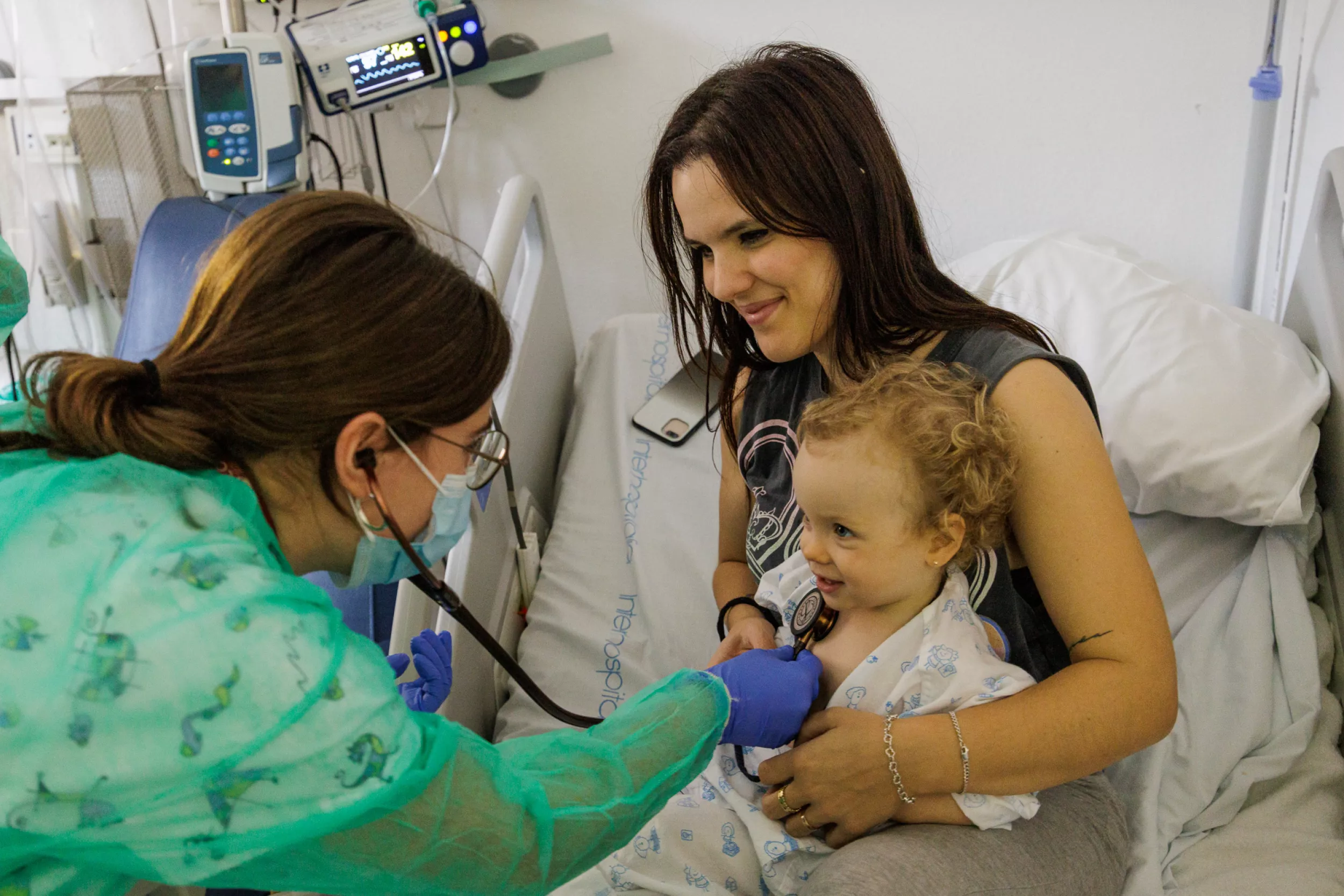Una doctora auscultat una nena amb la seva mare.