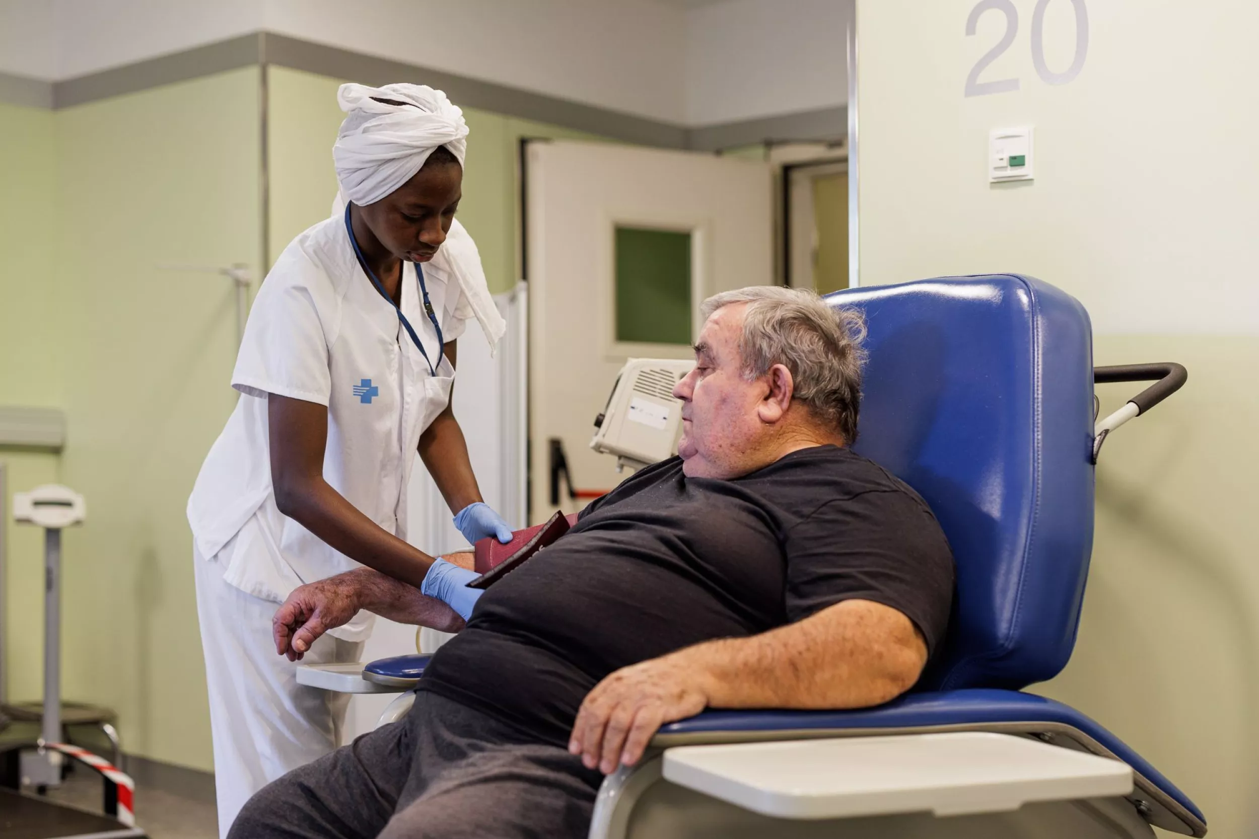 Una infermera prenent-li la tensió a un pacient