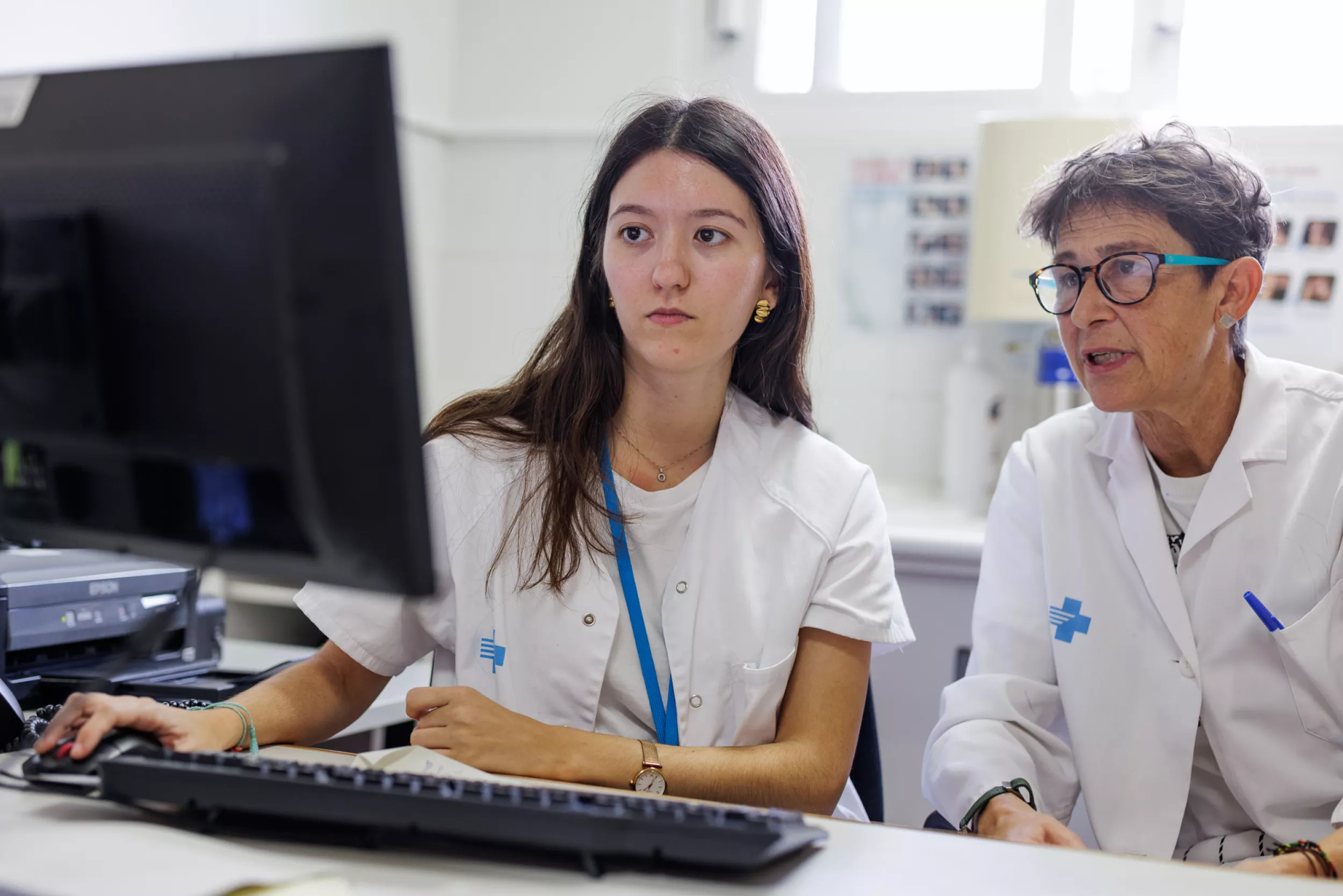 Una resident amb l'ordinador amb una metgessa