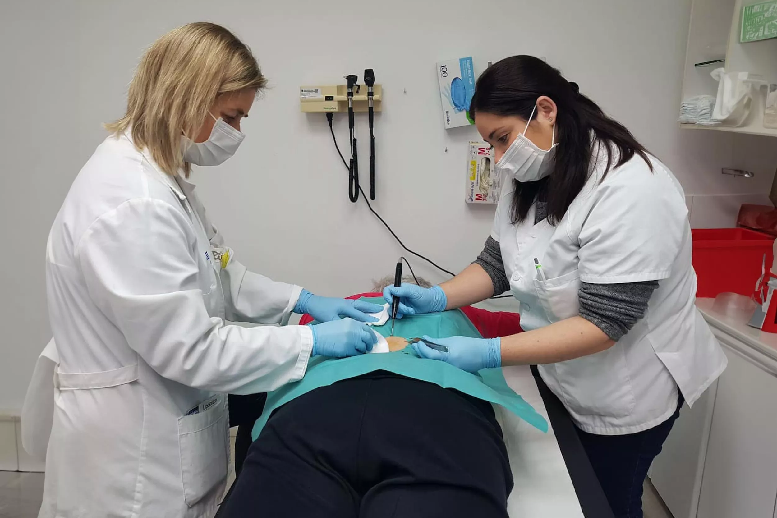 Médico y residente tratando a un paciente la parte baja de la espalda