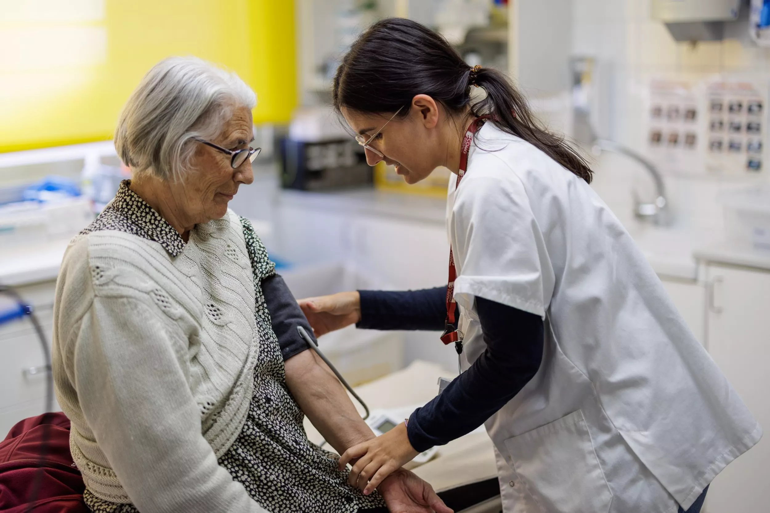 Professional sanitari prenent la pressió arterial a una pacient gran