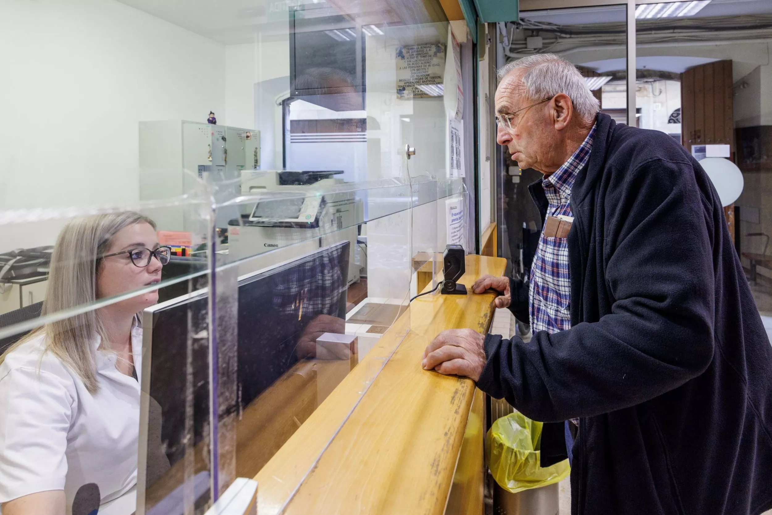 Taulell d'un CAP, administrativa atenent una persona
