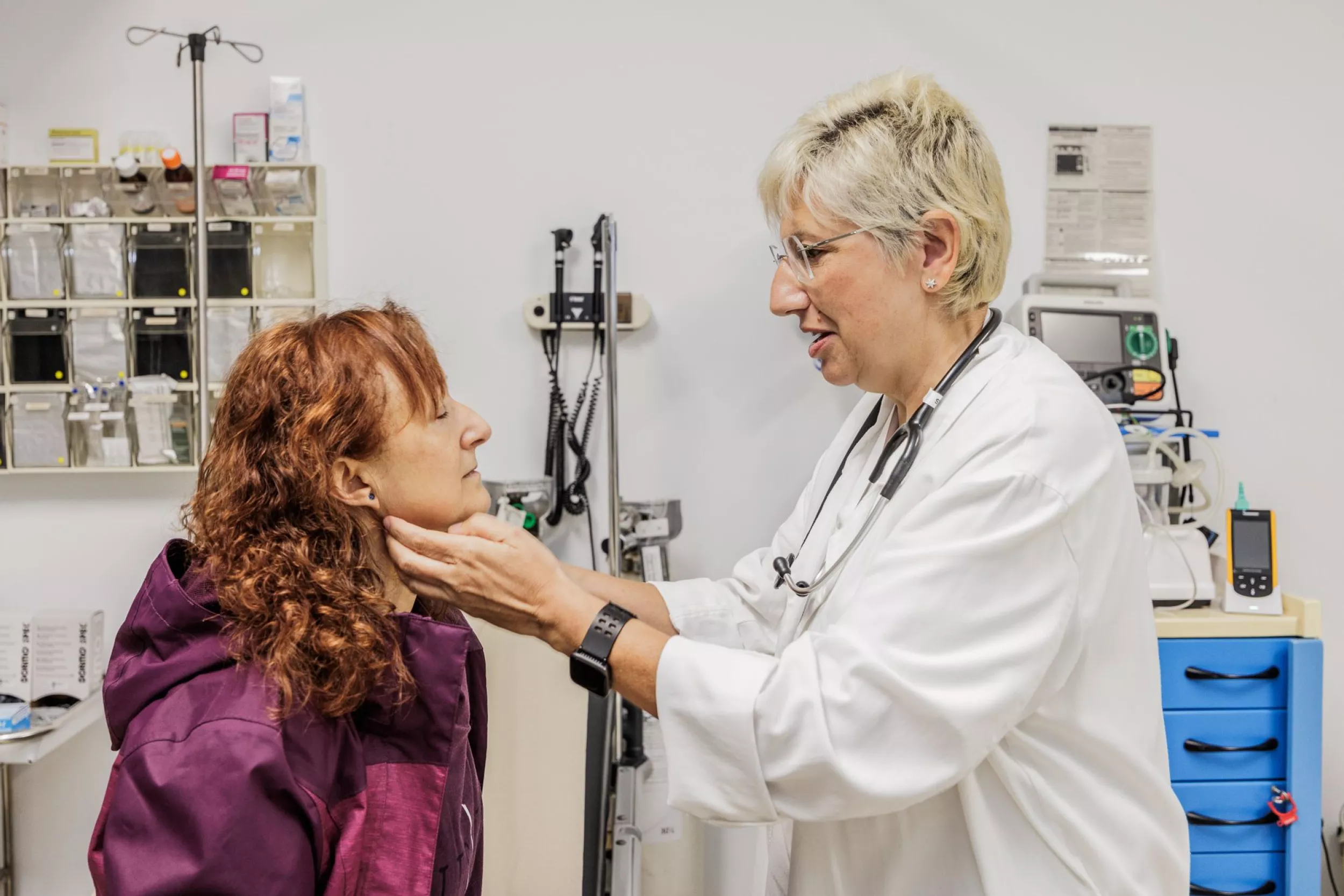 Doctora examinant el coll d'una pacient en una consulta mèdica