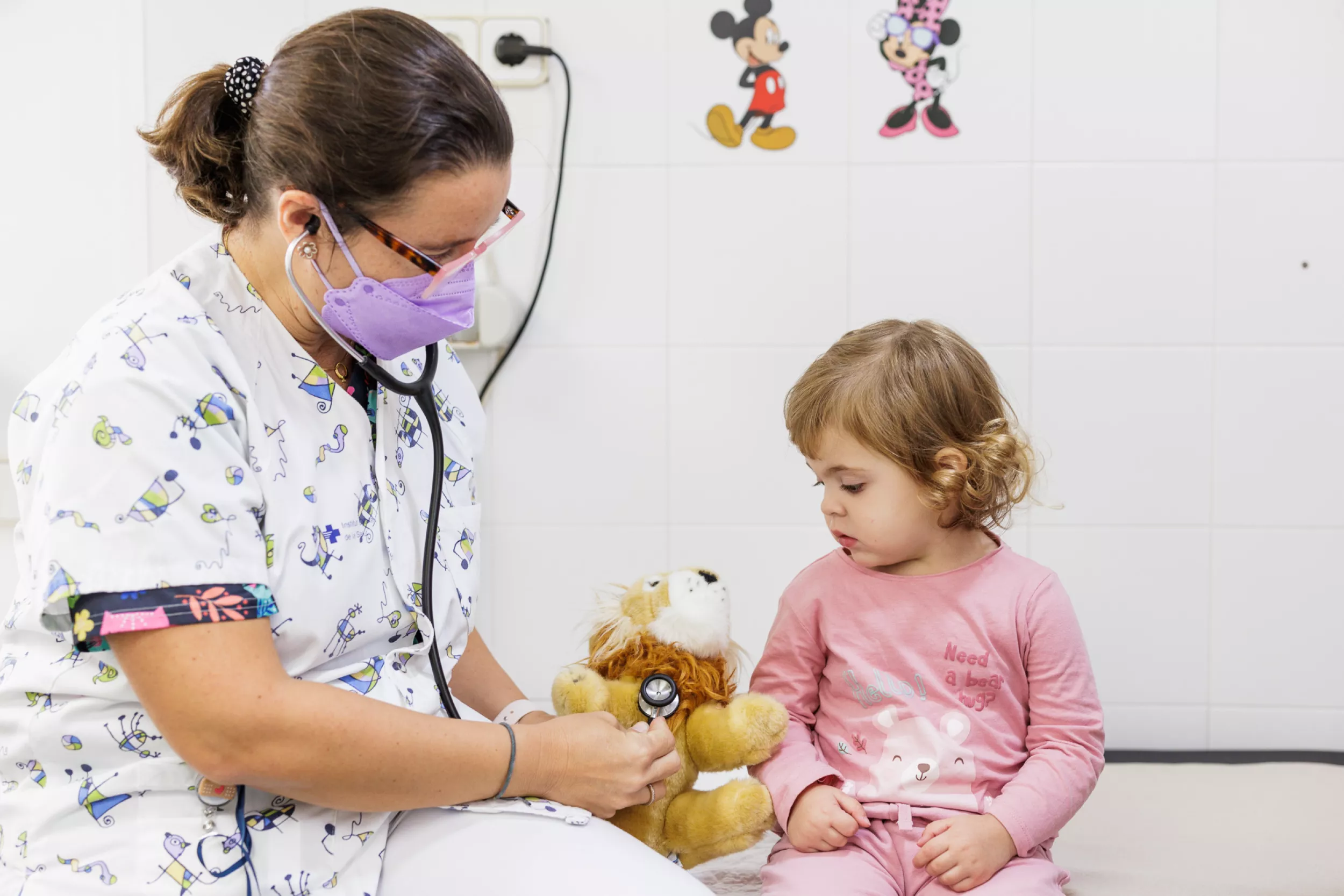 Una pediatra auscultant un peluix d'una nena.