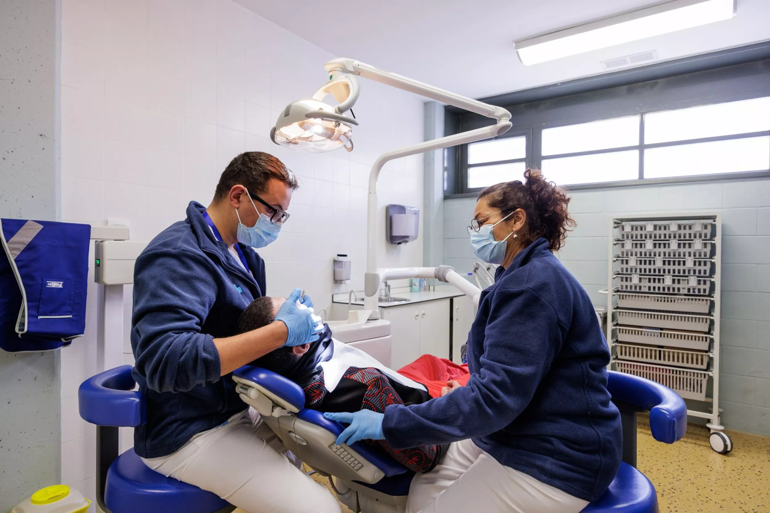 Profesionales sanitarios atendiendo a un paciente en una consulta odontológica