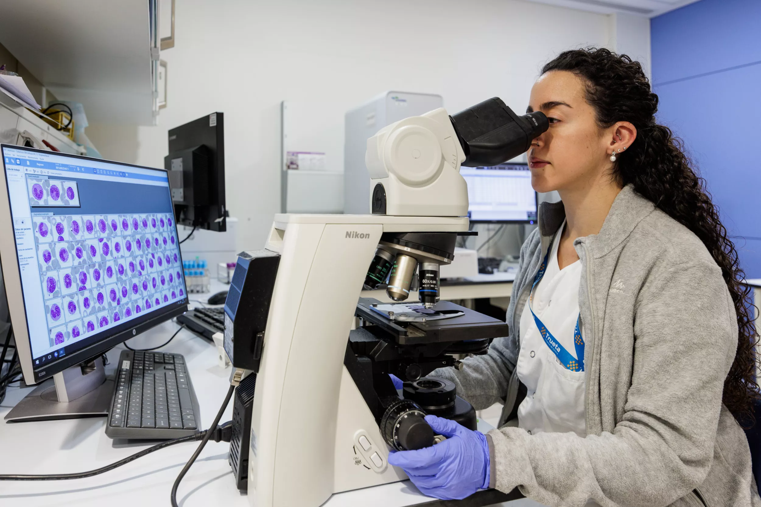 Metge analitzant mostres amb un microscopi en Anàlisis Clíniques