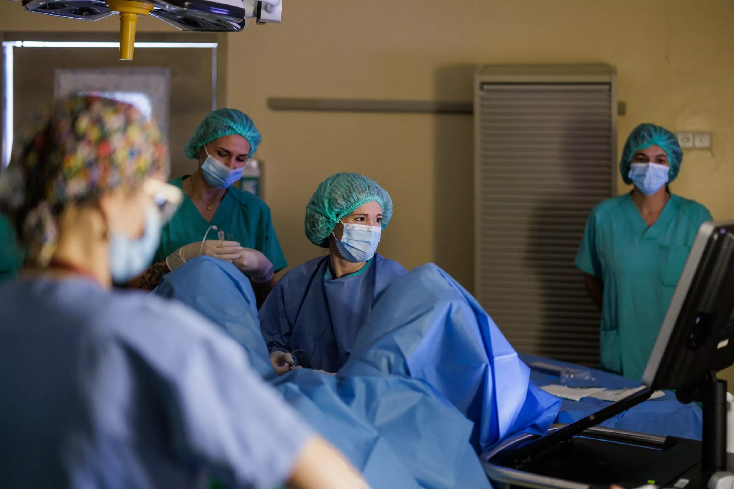 Diversos metges de ginecologia amb una pacient en una llitera