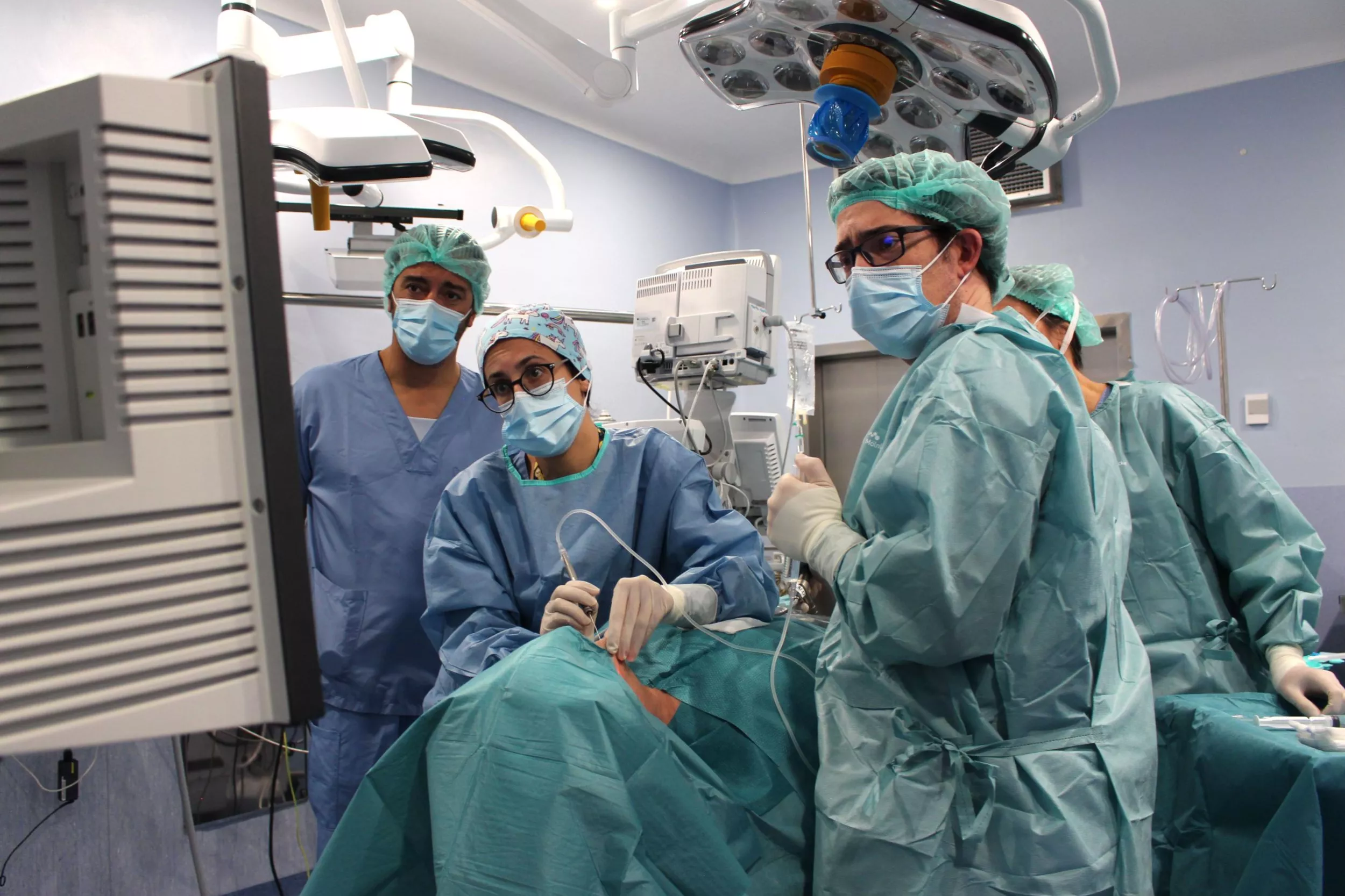 Metges i infermeres mirant una pantalla en un quiròfan