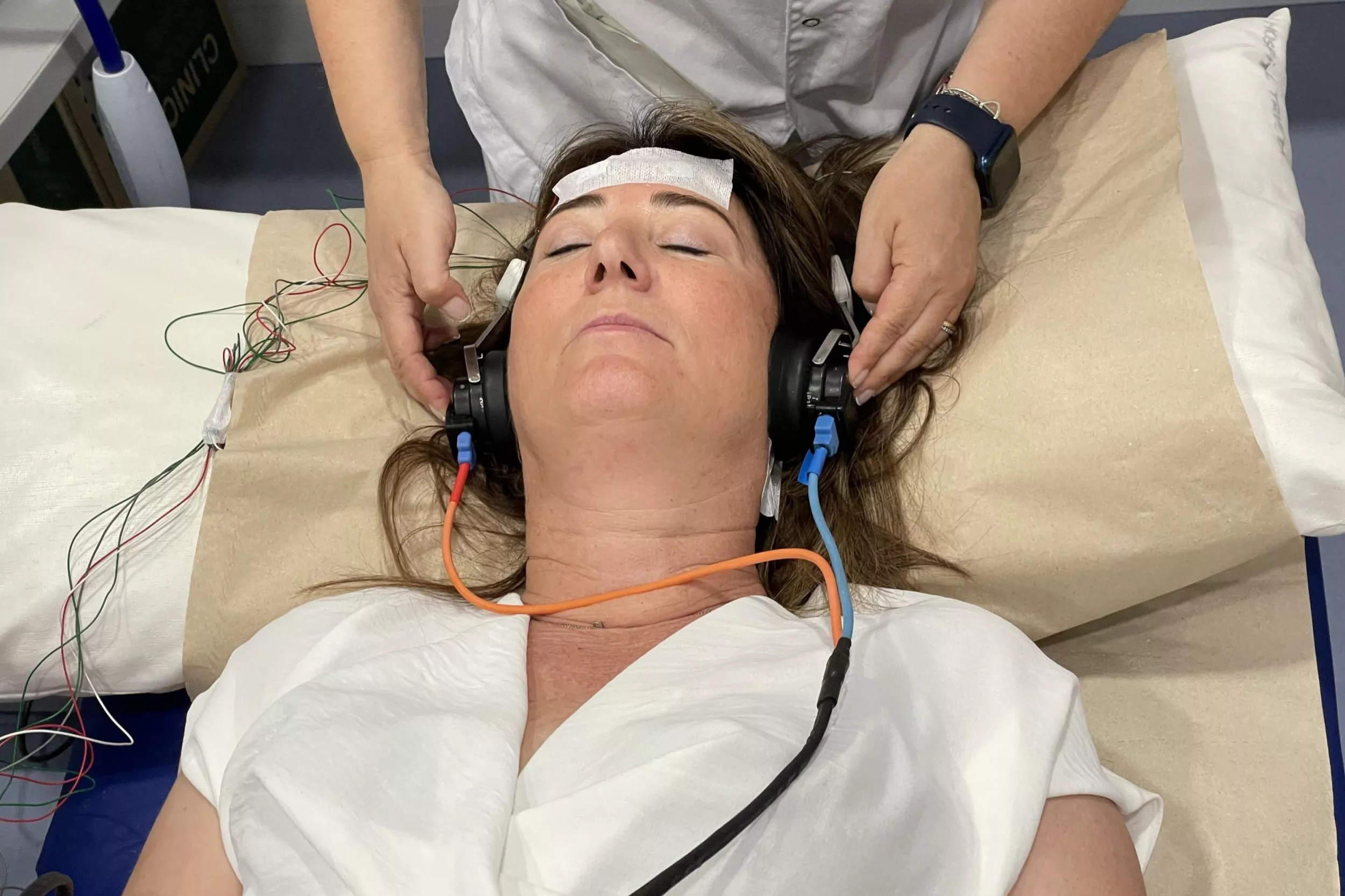 Pacient de Neurofisiologia tombada en una llitera amb uns cables i sensors al voltant del cap
