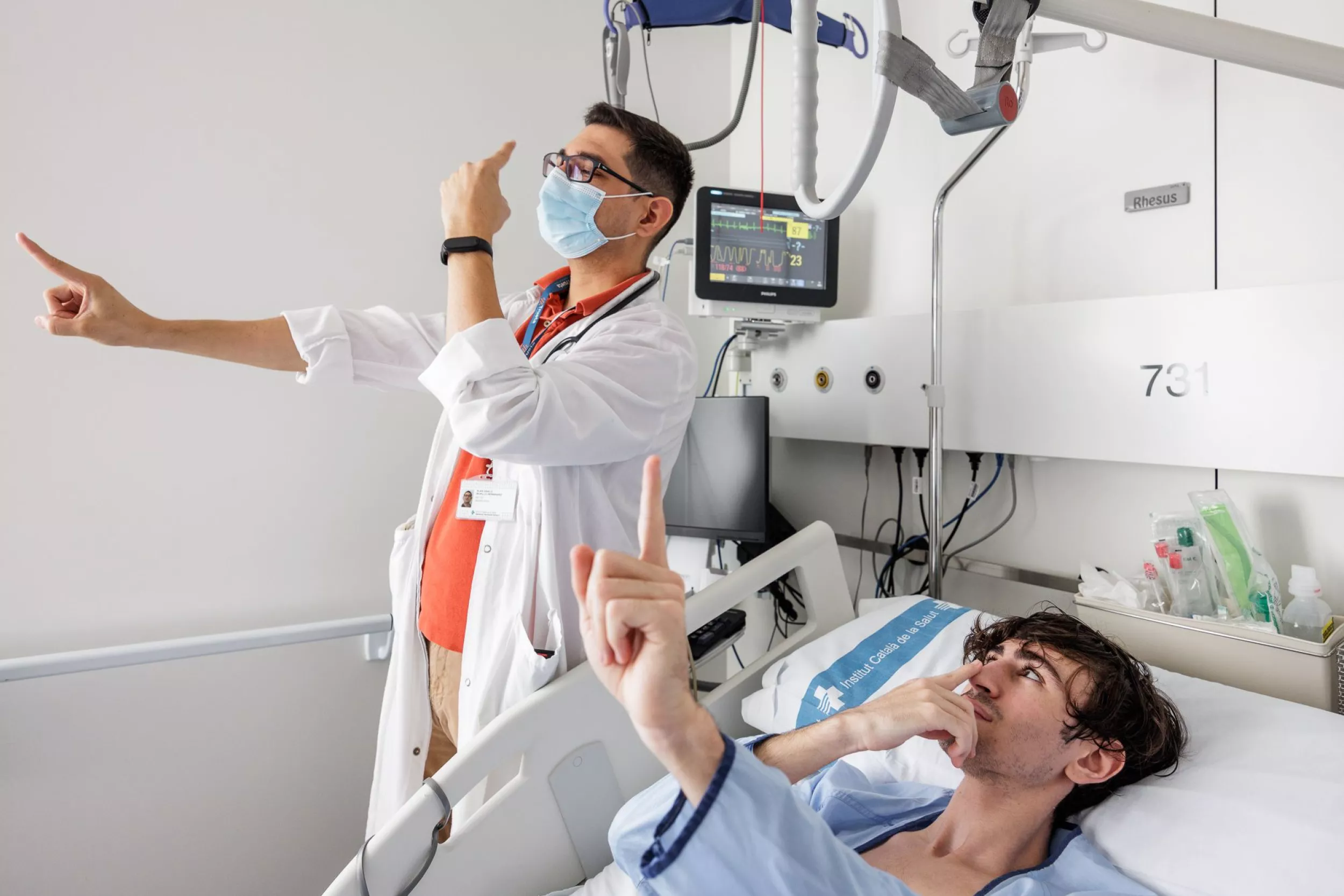 Metge fent unes proves de neurologia a un pacient en una llitera a l'habitació de l'hospital