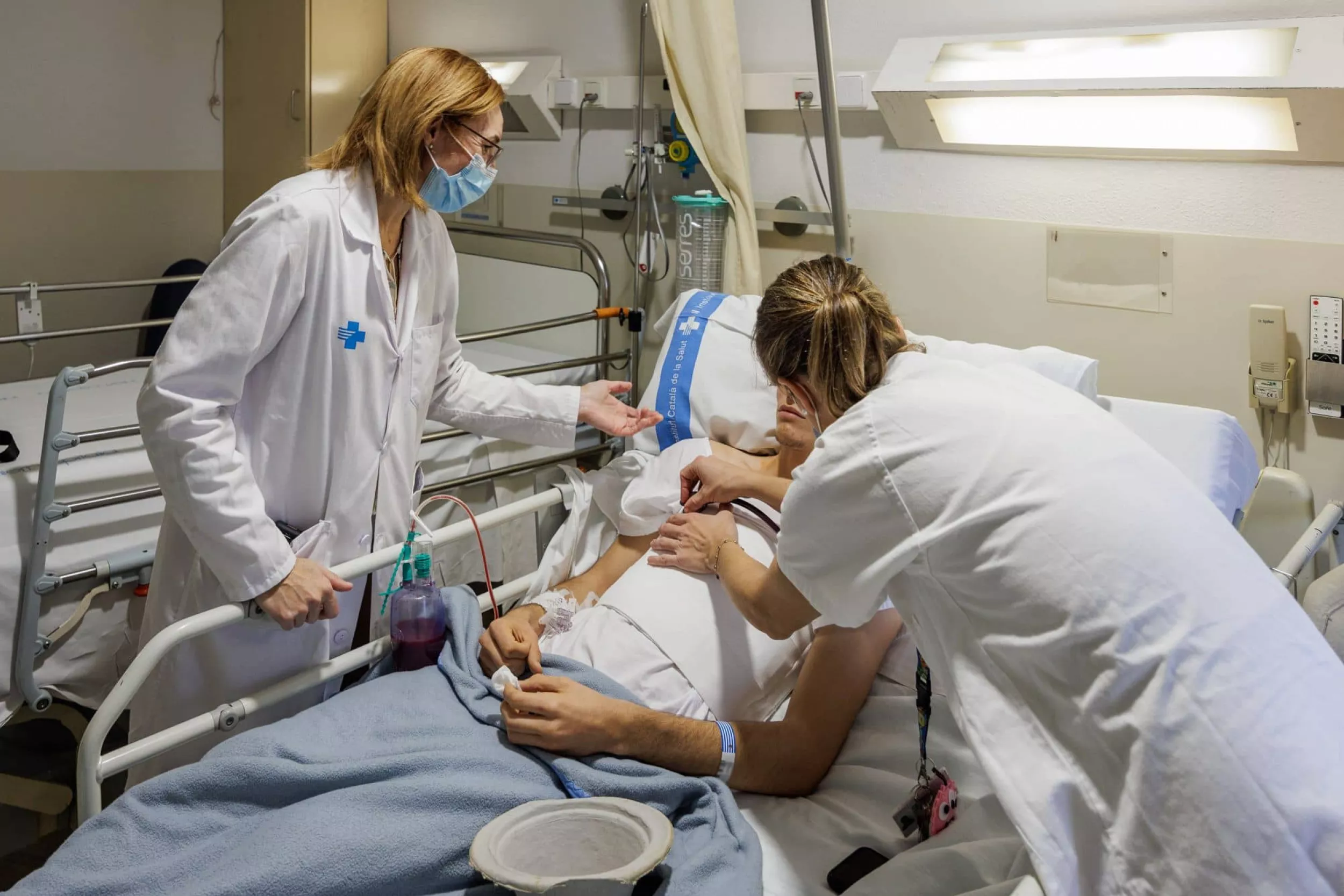  Metges de cirurgia toràcica parlant amb un pacient recent operat