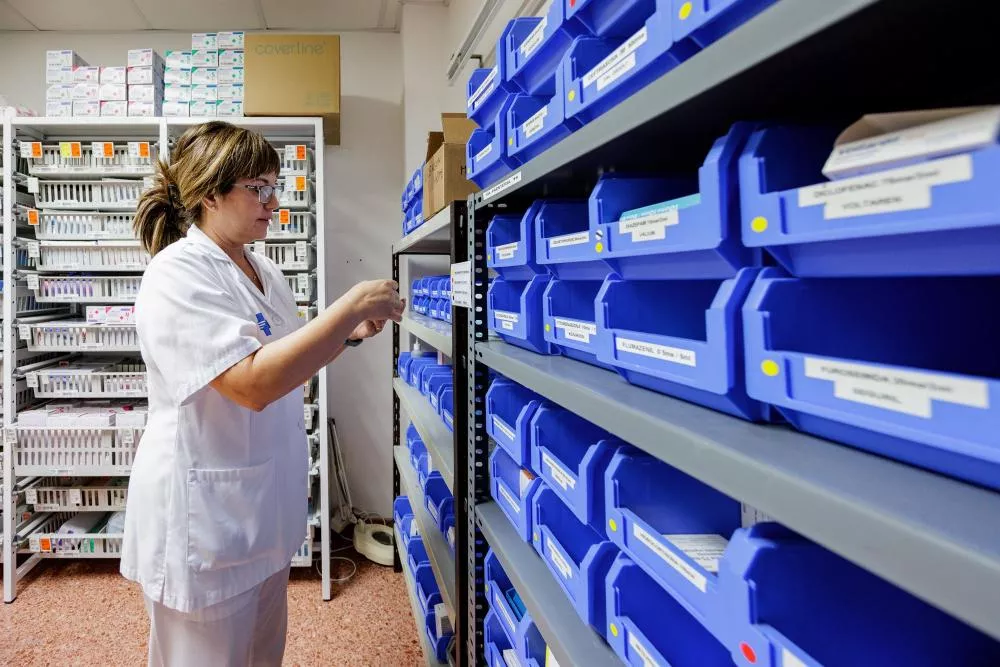 Administrativa del CAP clasificando documentos en cajones