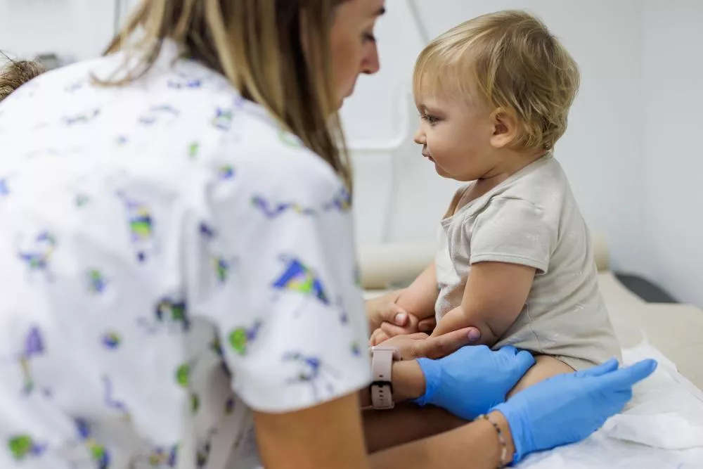 Médico poniendo vacuna a un bebe
