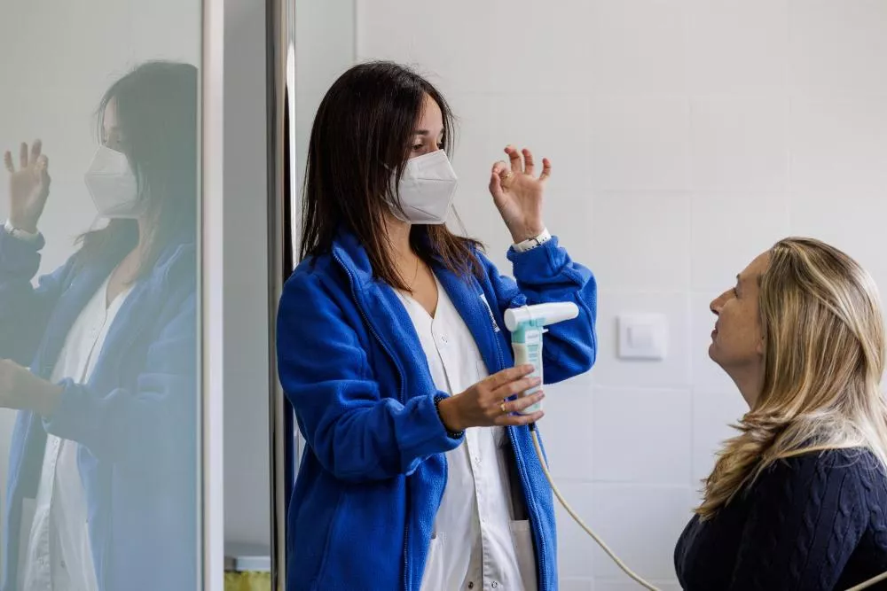 Médico haciendo una prueba de respiración a una paciente