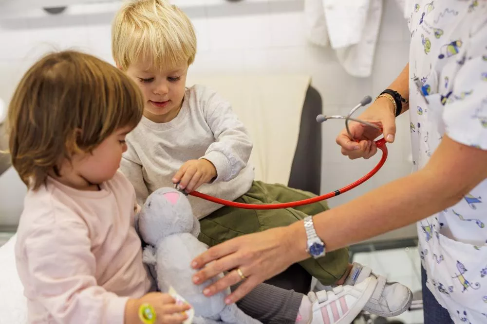 Médico con dos niños pequeños