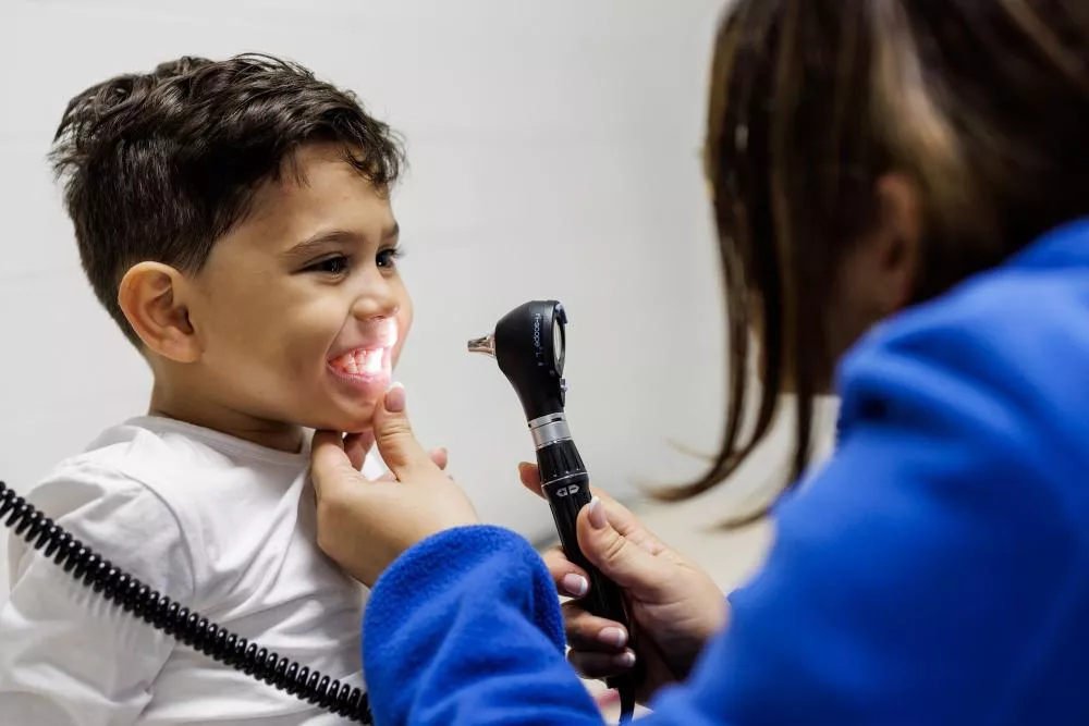 Médico mirando los dientes de un niño