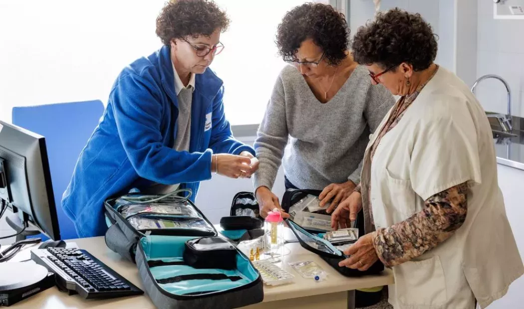 Trabajadoras del hospital enseñando un dispositivo a una paciente