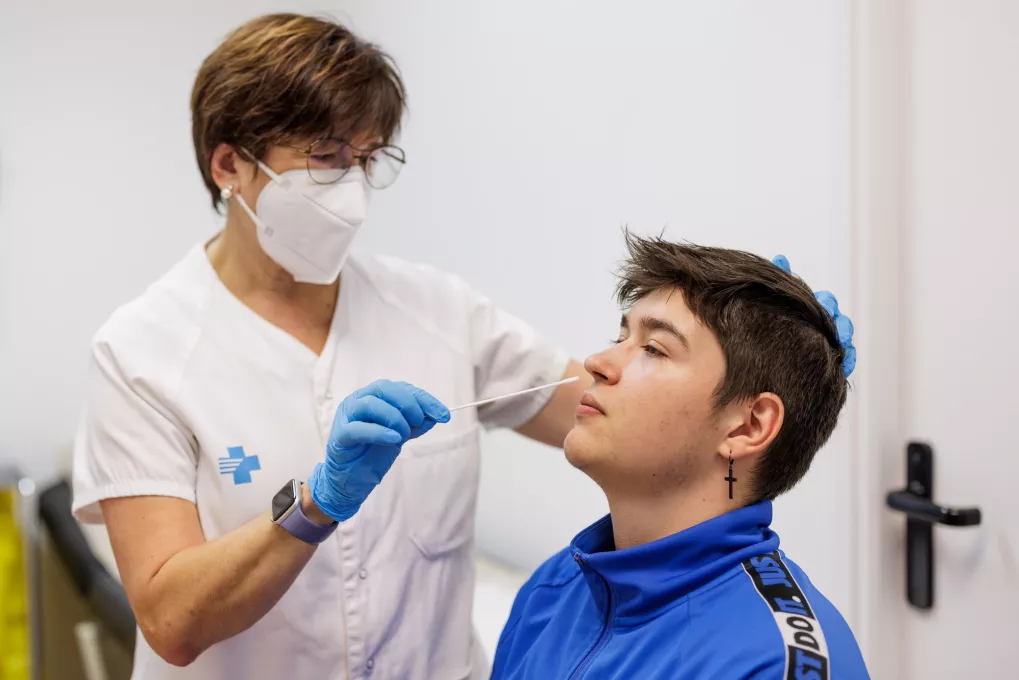 Enfermera haciendo un test de COVID a un adolescente