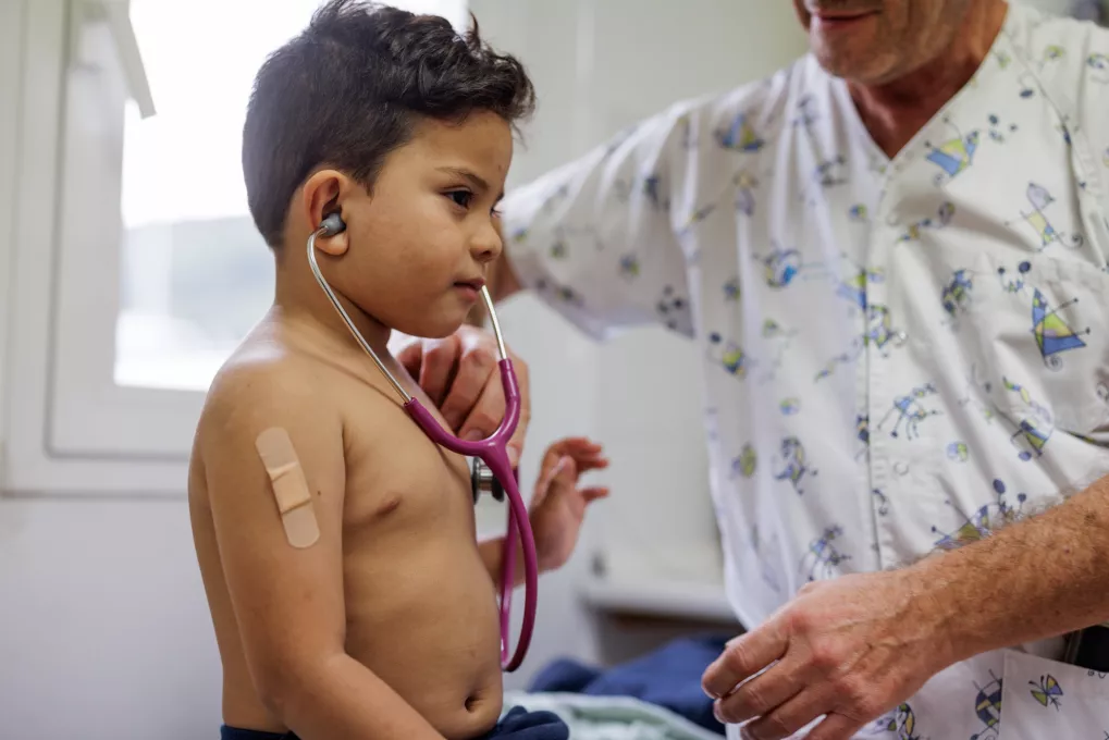 Un pediatra atendiendo a un niño.