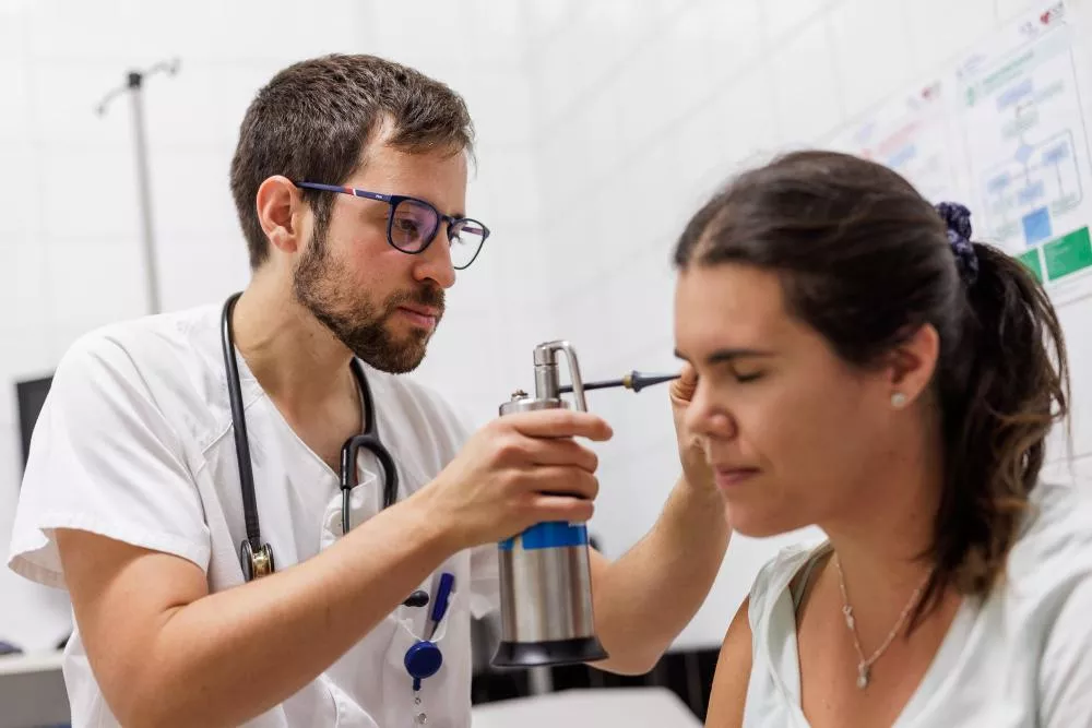 Médico tratando el oído de una paciente