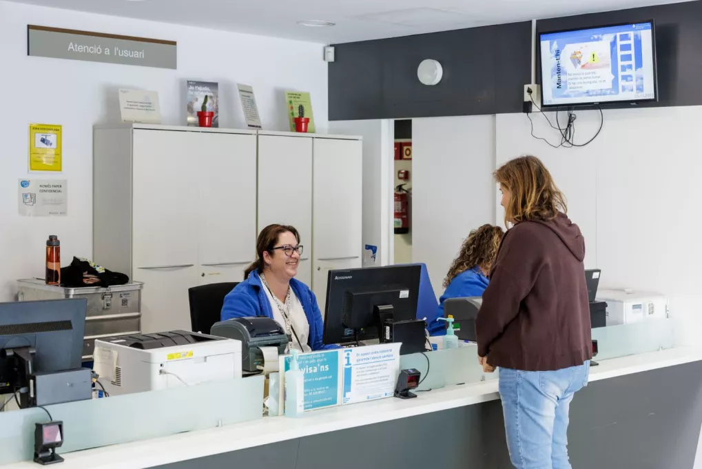 Una professional de l'equip d'atenció primària de Canet atén una usuària al taulell d'informació