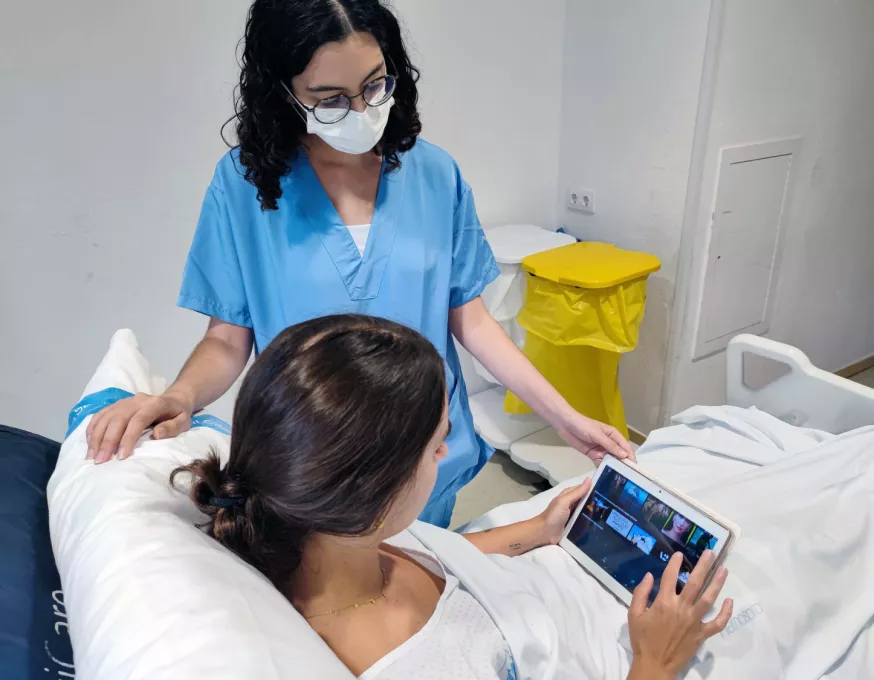 La infermera Laura Cano facilita la tauleta per realitzar l'estudi sobre l'efecte de la distracció audiovisual i musical en l'ansietat de les persones postoperades.