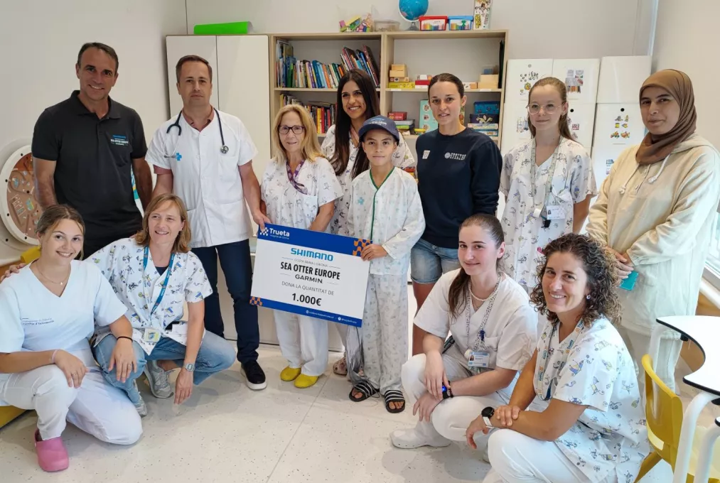 El director de Sea Otter Europe i la ciclista Txell Figueras,  acompanyats per professionals i pacients del Servei de Pediatria del Trueta.