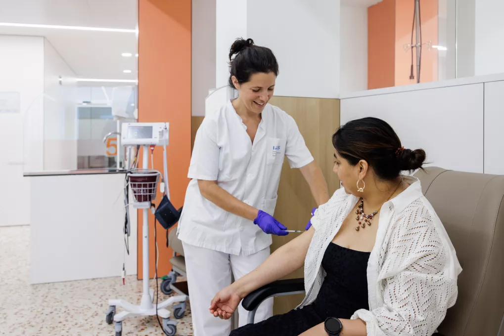 Una professional d'infermeria atén una usuària de l'Hospital de Dia de l'IAS