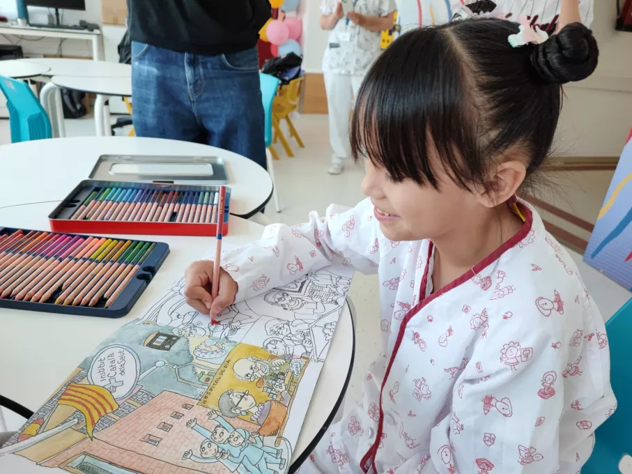 Una pacient ingressada a l'àrea de pediatria del Trueta amb el quadern per acolorir de Pilarín Bayés dedicat al Trueta