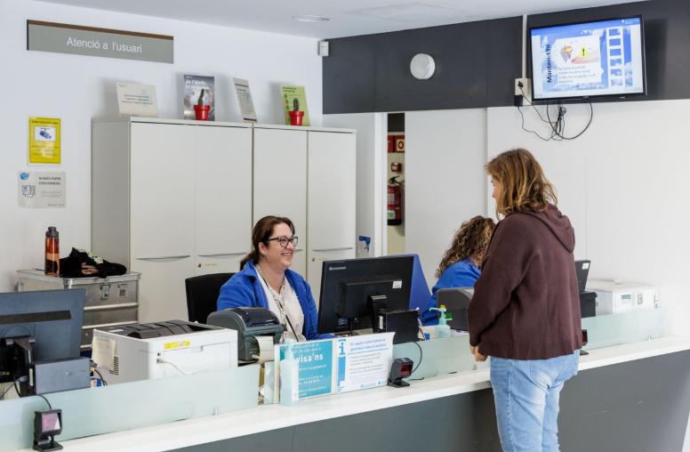 Una professional de l'equip d'atenció primària de Canet atén una usuària al taulell d'informació