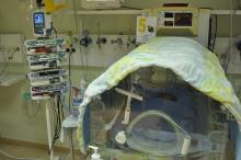 una incubadora amb un nadó a la Unitat de Cures Intensives Neonatal