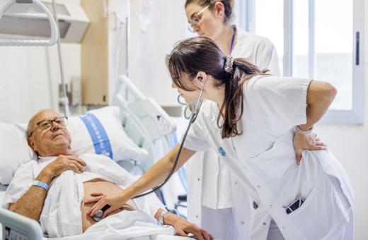 Una professional del Servei de Cirurgia General del Trueta atén una persona ingressada al centre.