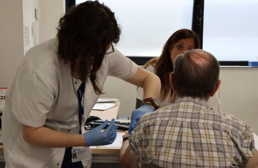 Una professional administra una vacuna durant un assaig clínic.