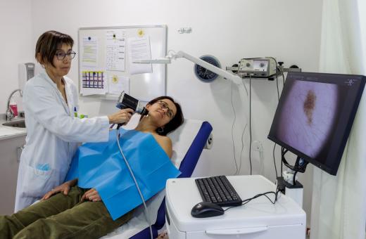 Una professional del Servei de Dermatologia del Trueta i el Santa Caterina realitza una exploració amb el dermatoscopi digital