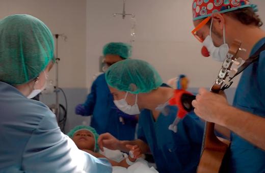 Un infant ja a quiròfan durant la inducció a l'anestèsia i acompanyat per un familiar i un component de Pallapupas. 