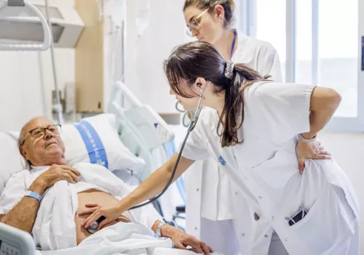 Una professional del Servei de Cirurgia General del Trueta atén una persona ingressada al centre.