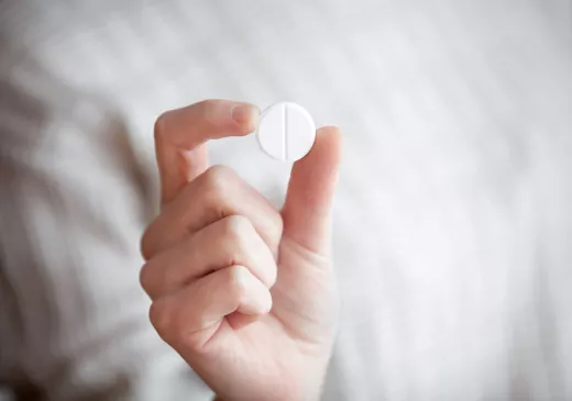 Una persona subjecta una aspirina 