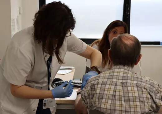 Una professional administra una vacuna durant un assaig clínic.