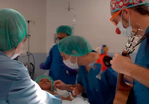 Un infant ja a quiròfan durant la inducció a l'anestèsia i acompanyat per un familiar i un component de Pallapupas. 