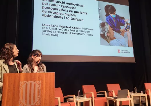 Les infermeres Laura Cano i Meritxell Comas exposen el seu estudi sobre la reducció de l'ansietat postoperatòria mitjançant distracció audiovisual i musical durant la jornada d'experiència del pacient.